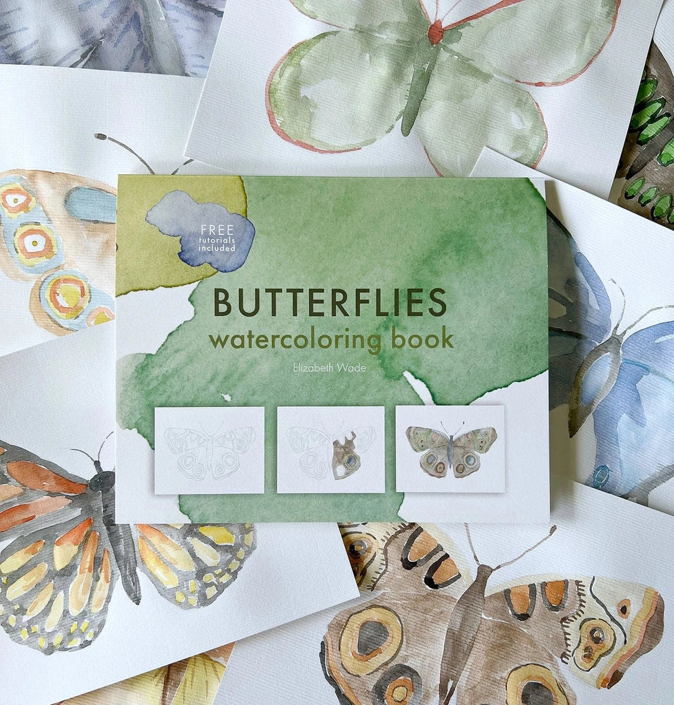 Watercolor butterfly book surrounded by butterfly paintings.