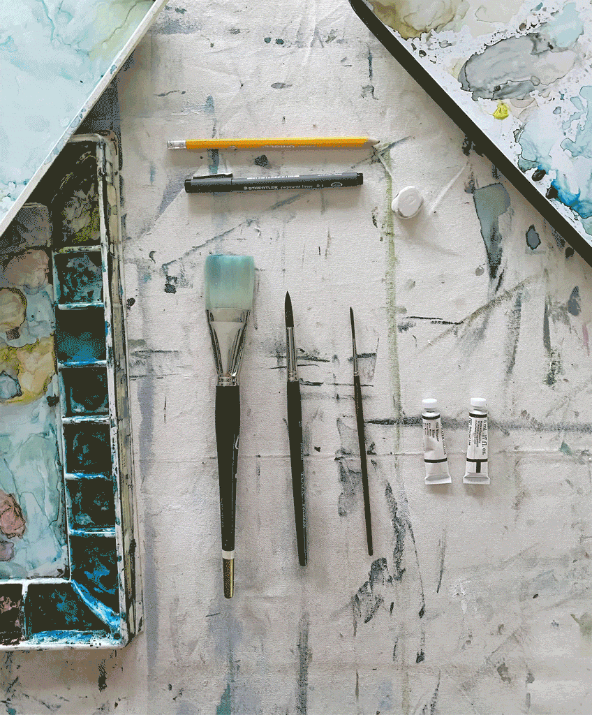 Paint palettes, brushes, pencils, and paint tubes on a messy surface.